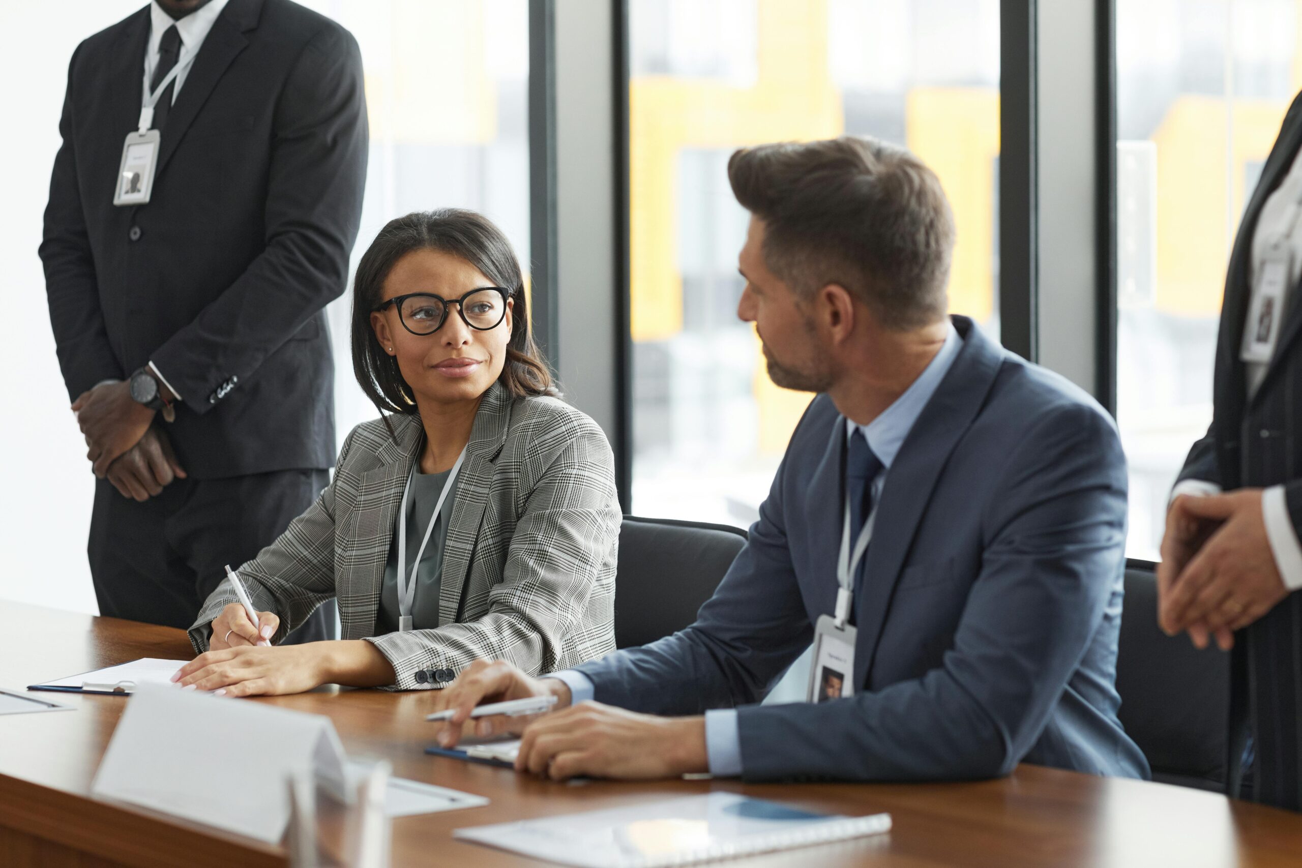 About 1 Diverse business professionals discussing strategy during a modern board meeting.