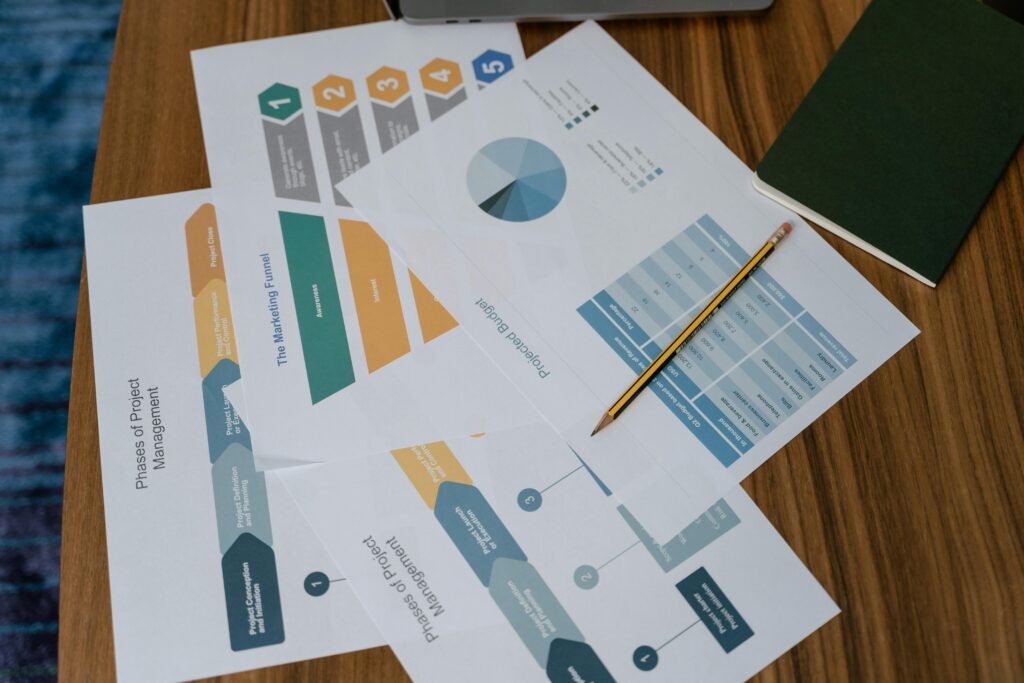 Services 3 Overhead view of project management documents and charts on a desk with a pencil.